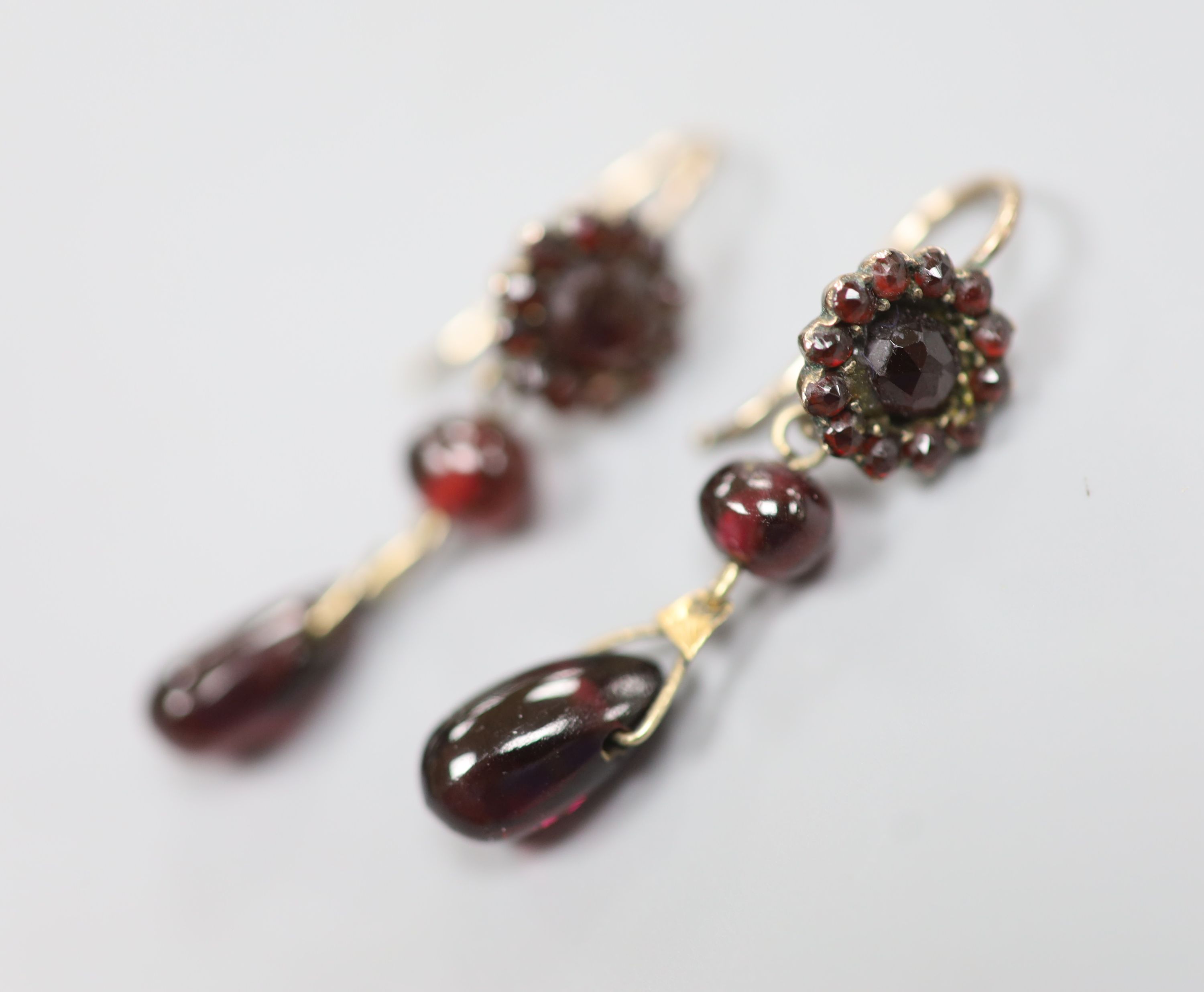 A pair of late Victorian gilt white metal?, facet, bead and pear shaped garnet set drop earrings